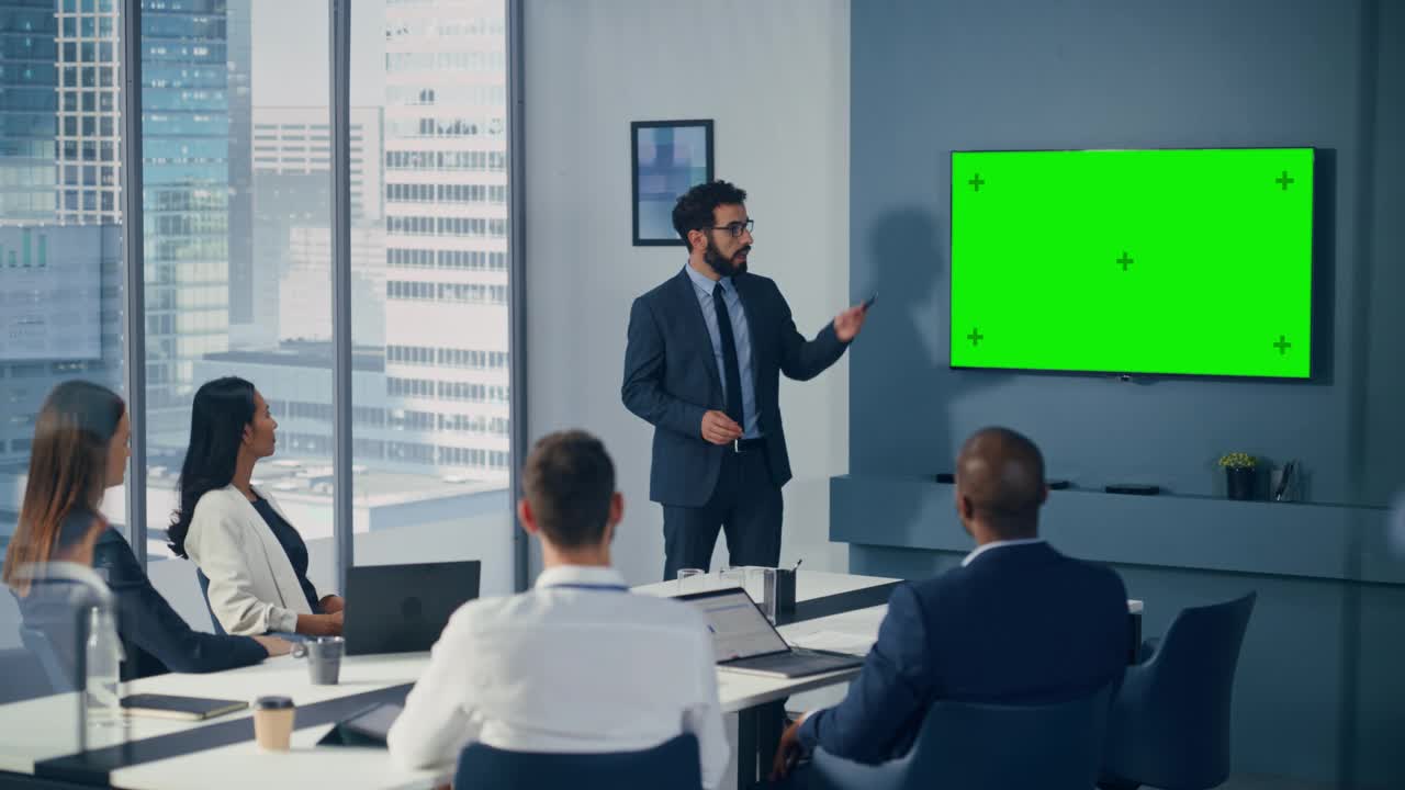 多元化办公室会议室会议:男项目经理利用绿屏色度键墙电视为集团投资者呈现机会。电子商务产品策略。中宽静态镜头视频下载