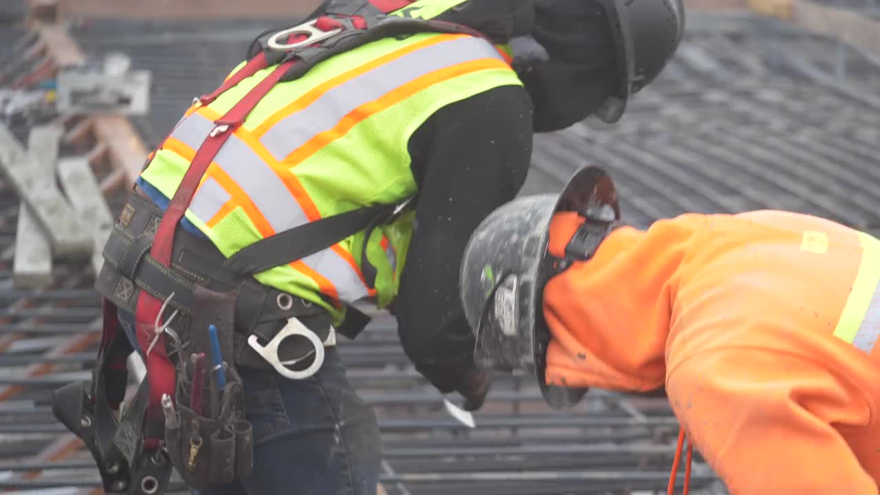 在一个大型商业工地，建筑工人正在为混凝土浇筑准备钢筋。视频素材