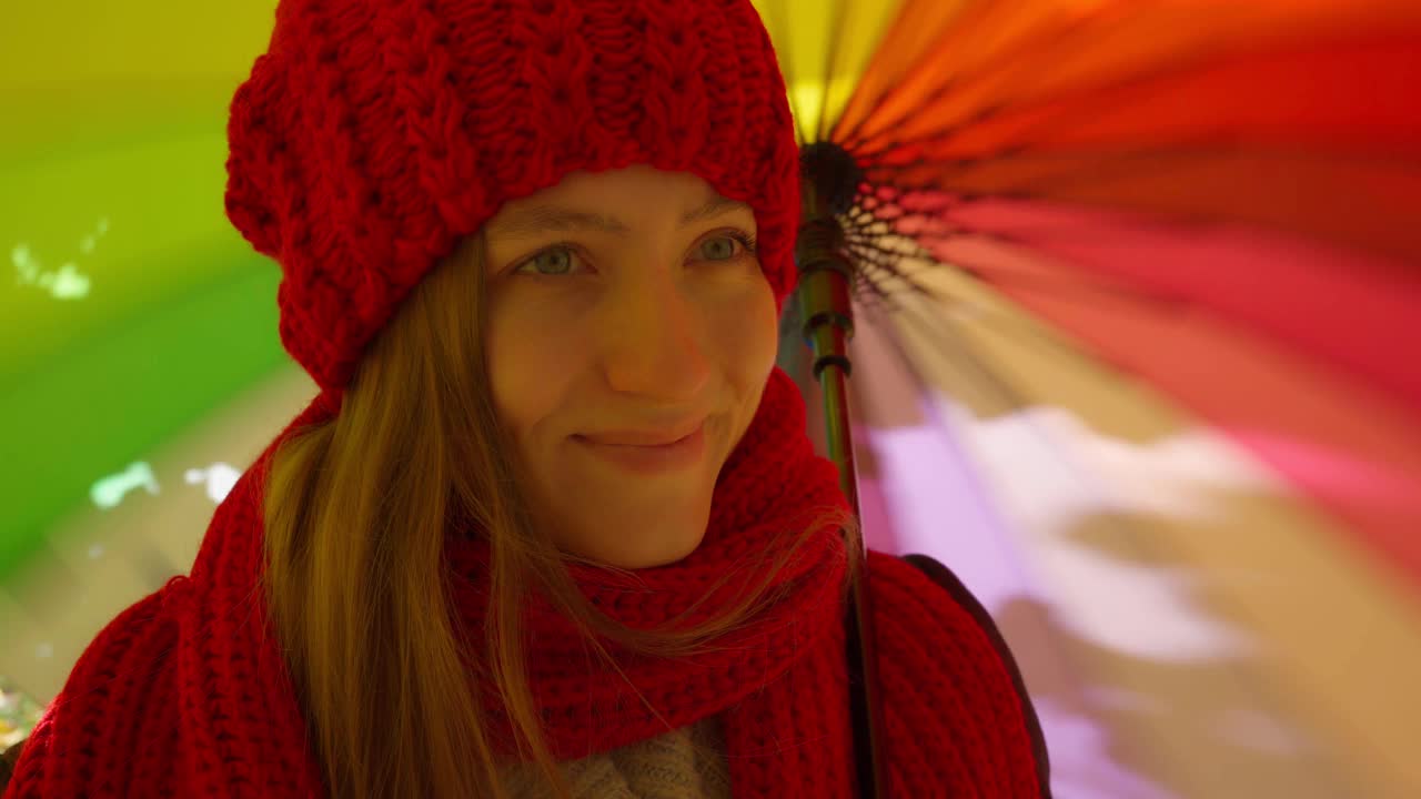 美丽快乐的女人打着伞站在公园里微笑。阳光明媚的视频素材