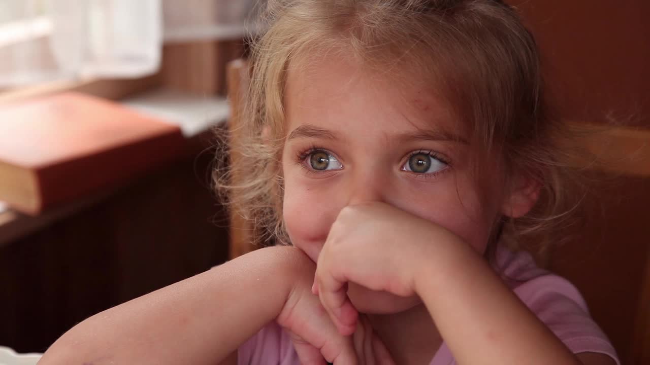 一个小女孩用手指扭动她疼痛的牙齿的特写镜头视频下载