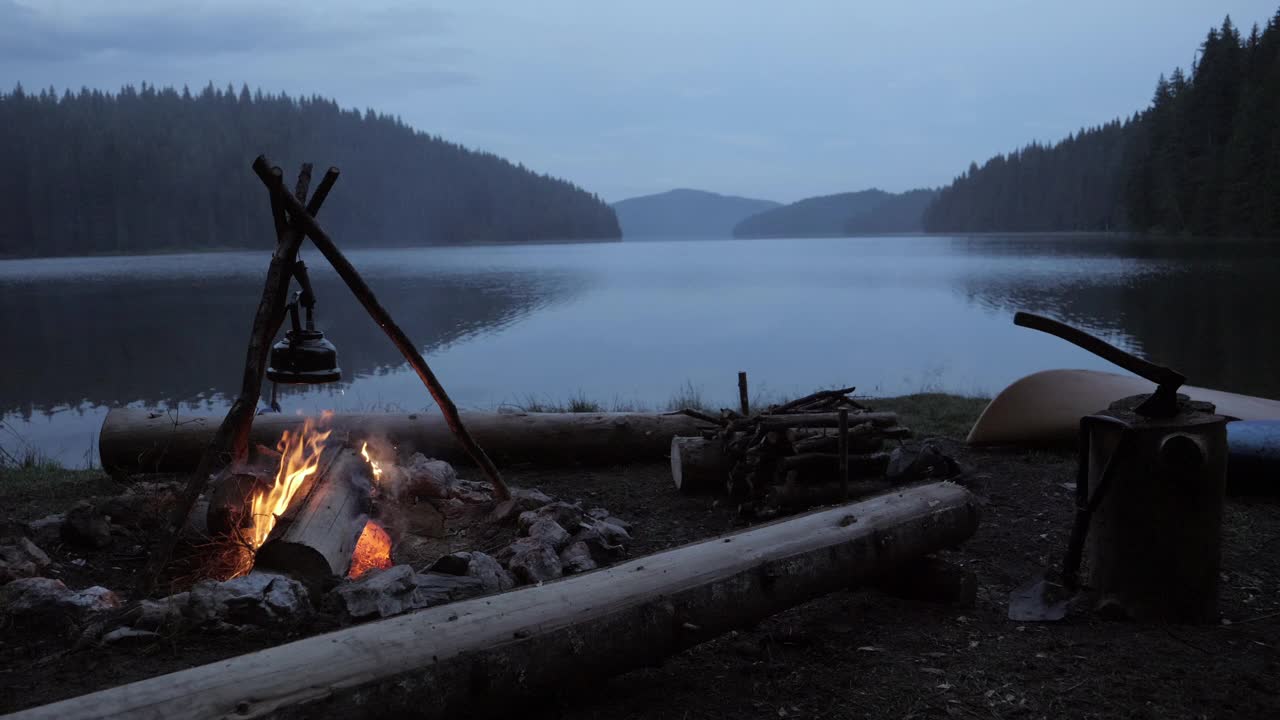 在湖边露营，在蓝色的时间里点燃篝火。视频素材
