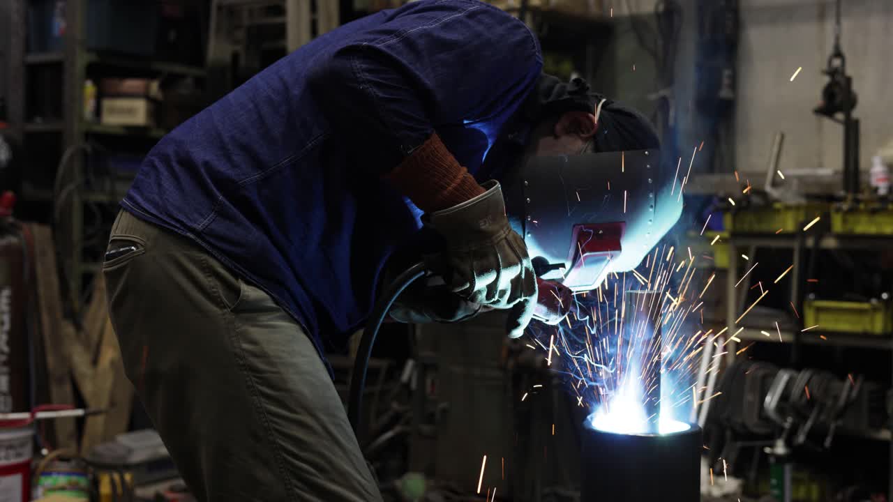 一名成熟的男子在一家小型焊接工厂里焊接视频下载