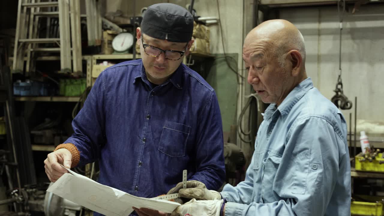 父子俩在一家小型焊接工厂工作视频下载