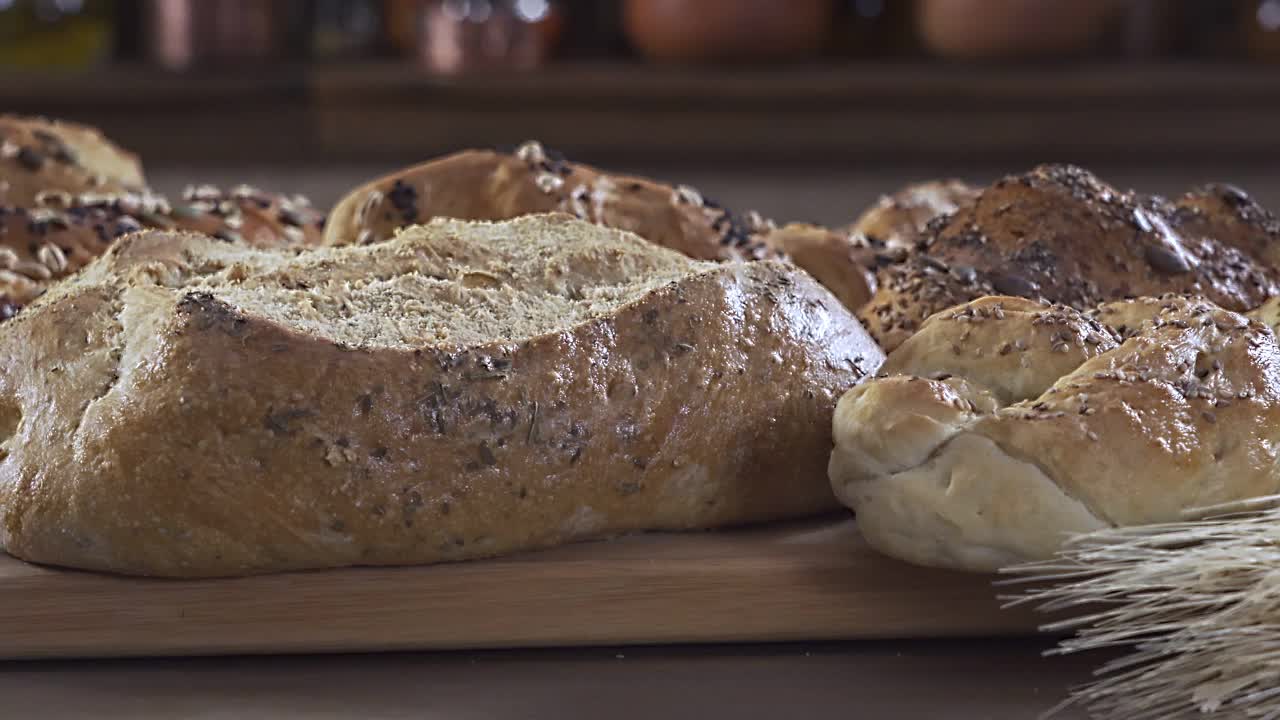 用慢镜头拍摄一组新鲜面包和烘焙食品的特写镜头。手工烘焙视频下载