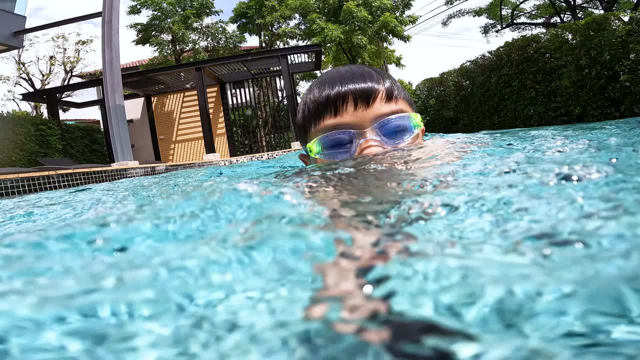 亚洲男孩在游泳池的水下玩耍和游泳视频素材