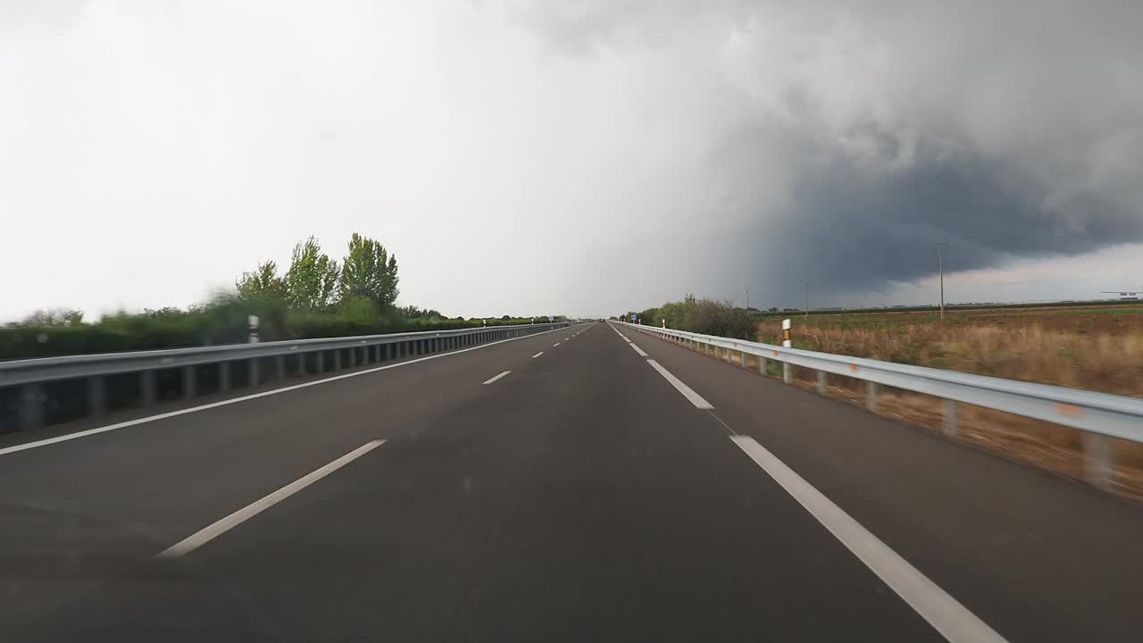 汽车视角驾驶，汽车行驶在直车道高速公路上驶向暴风雨。视频下载