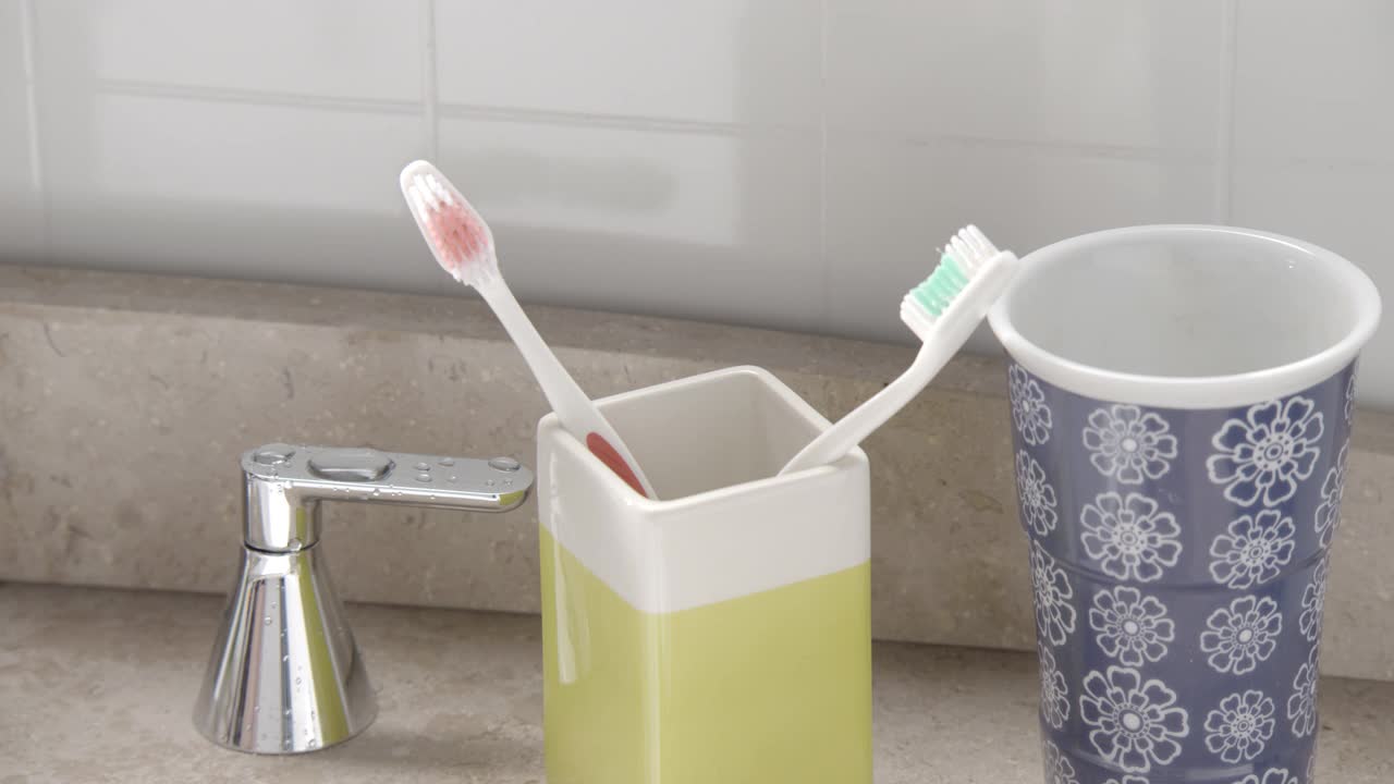 在浴室的支架上闭合角牙刷。水槽可见。视频素材
