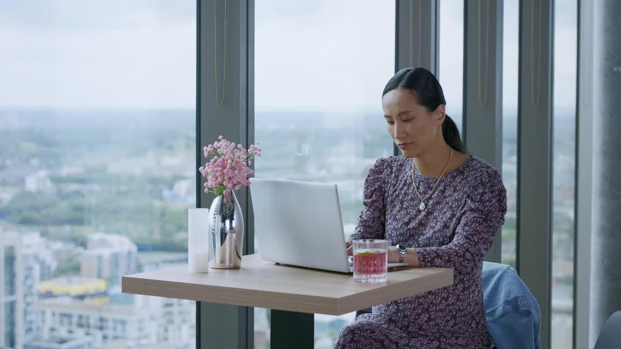 中年中国女商人在屋顶酒吧使用笔记本电脑视频下载