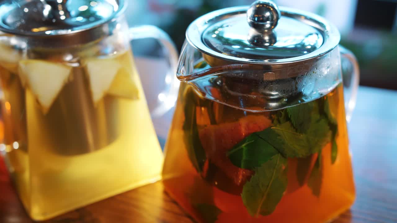 茶壶里的水果茶。花草茶。水果茶。茶饮料。特写镜头。三个玻璃茶壶，不同的水果和草药，五颜六色的茶视频素材