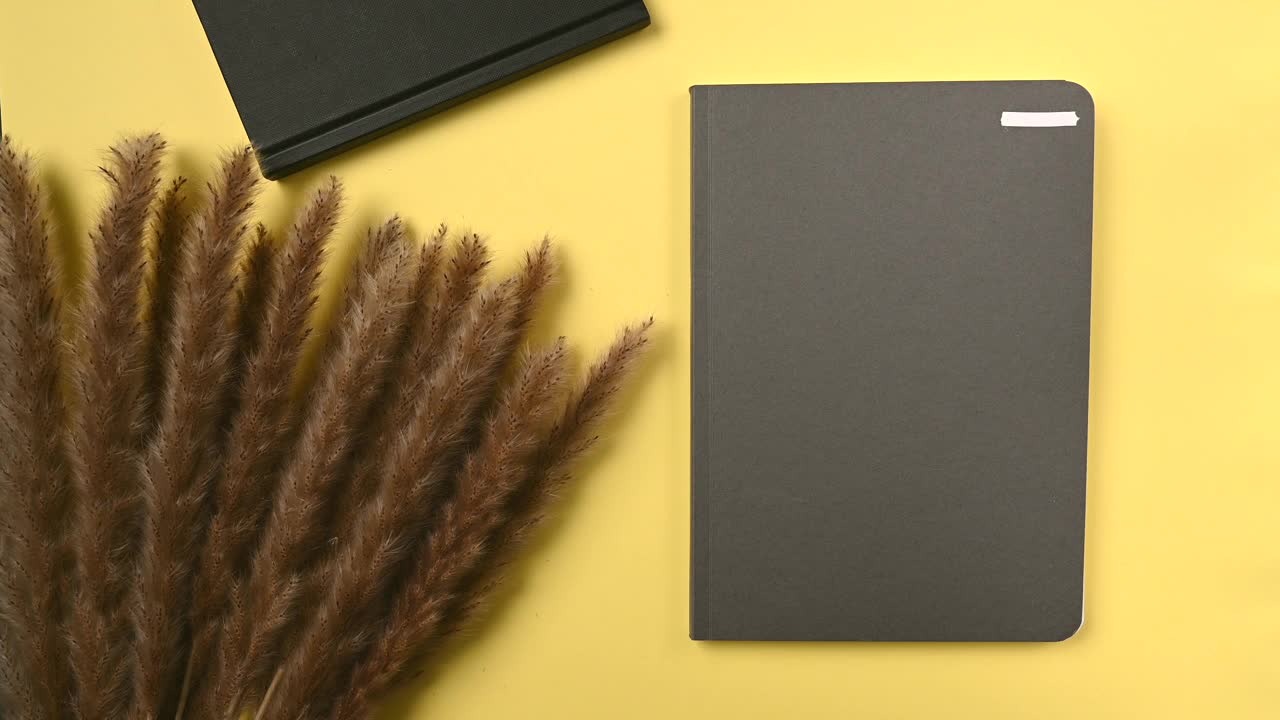 打开一个时髦的黄色背景的笔记本纸设计。平躺在一个现代化的工作场所。柔和的背景。视频下载