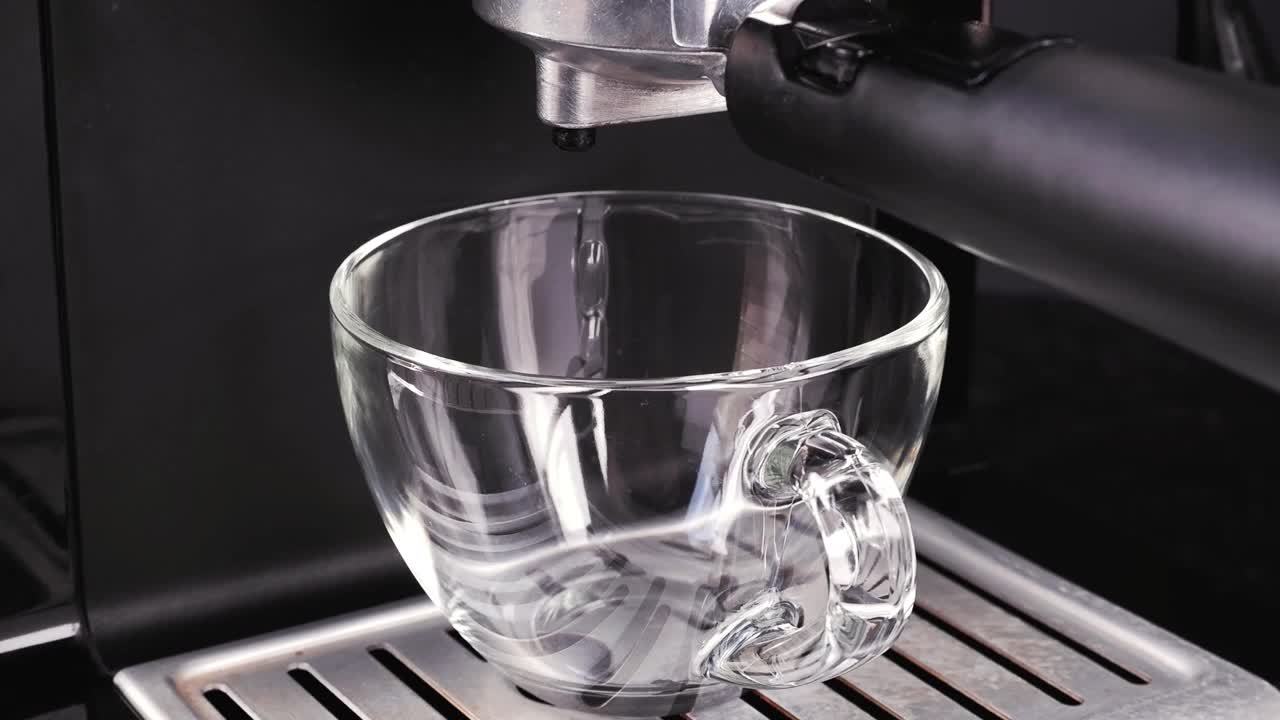 将咖啡机中的咖啡流倒入杯中，使用过滤器支架。流动的新鲜咖啡粉。自制热饮视频下载