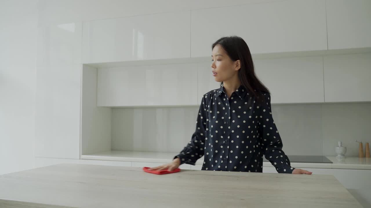 亚洲妇女在厨房用超细纤维布擦桌子。女人在家里做家务。家庭管理的概念视频素材