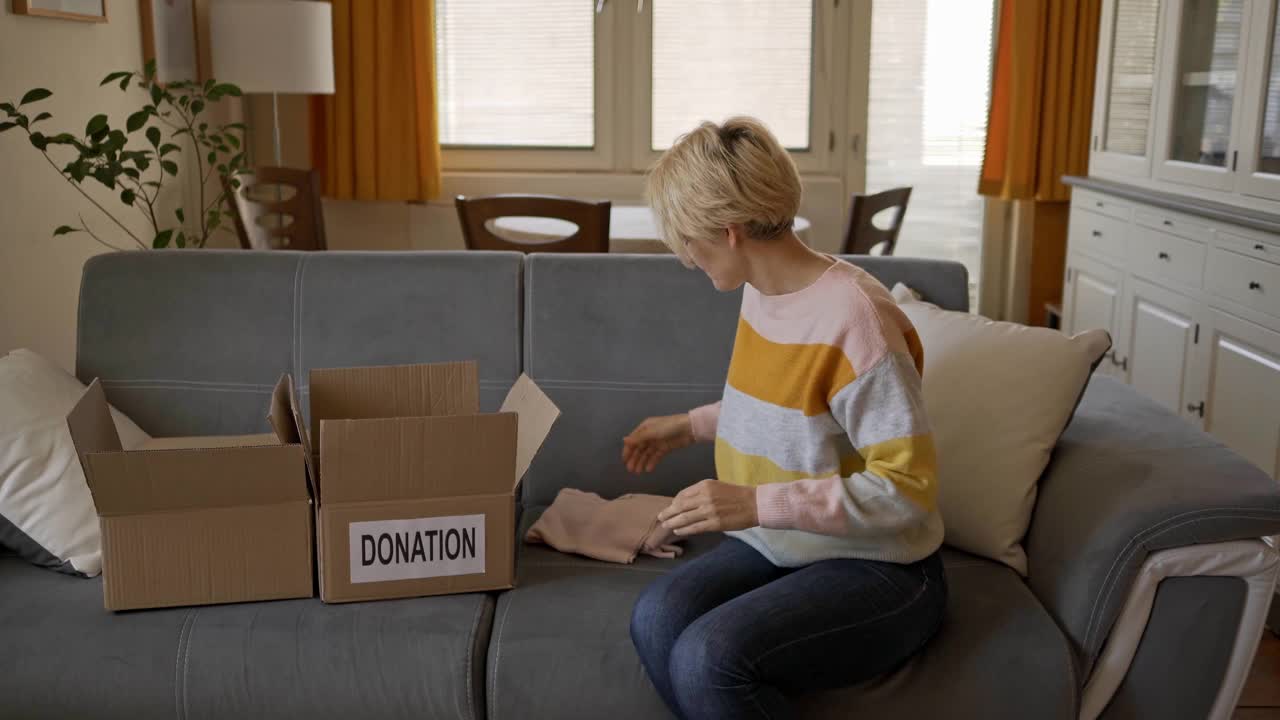 一位女士正在整理她的衣柜，并将其回收用于慈善捐赠视频素材