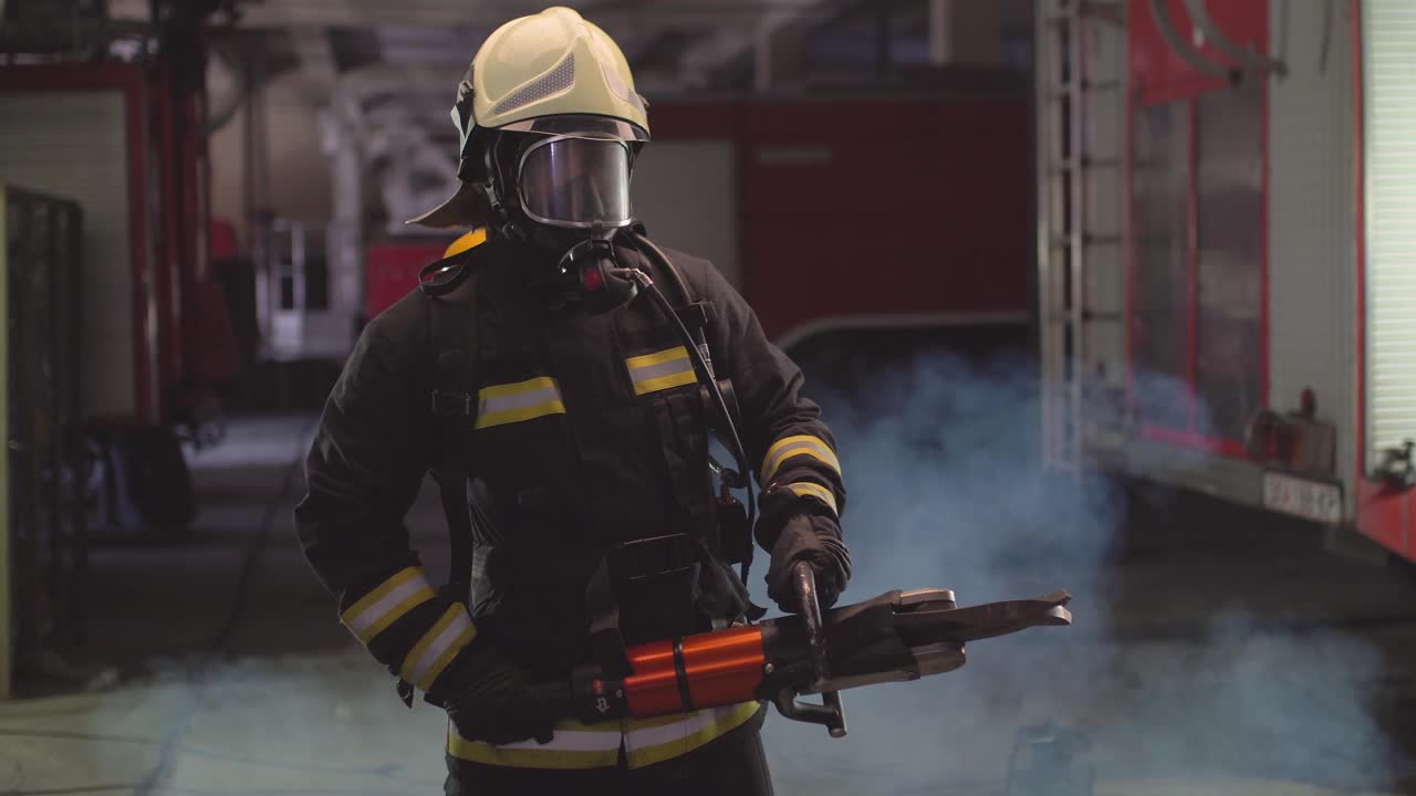 身穿全套装备、氧气面罩、电动液压切割工具的消防员肖像，背景是烟雾和消防车。姓名标签翻译为消防员和模特的姓。视频素材