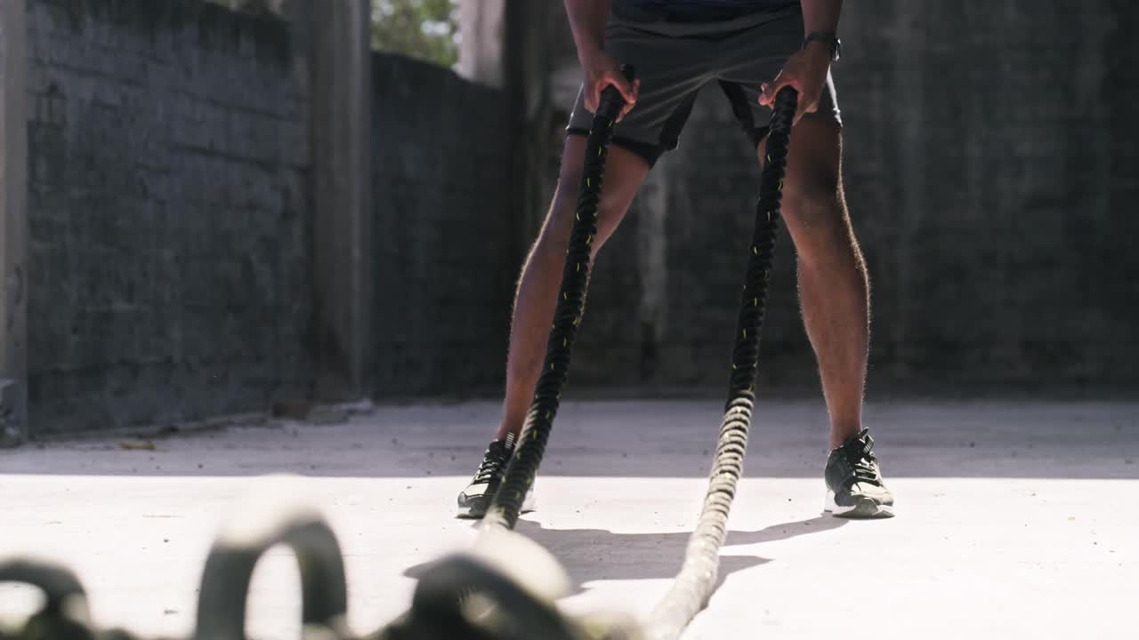 一个年轻人在城市背景下用绳索锻炼的4k视频片段视频素材
