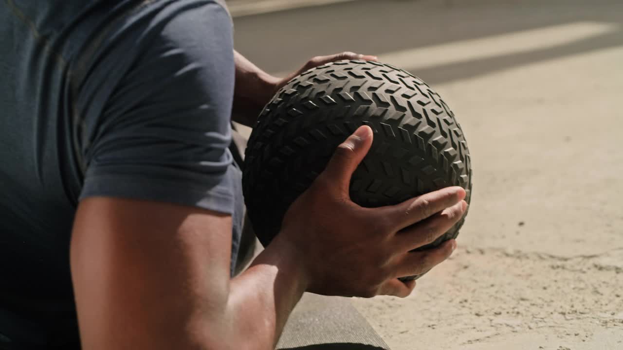 一名年轻人在城市背景下用实心球锻炼的4k视频片段视频素材