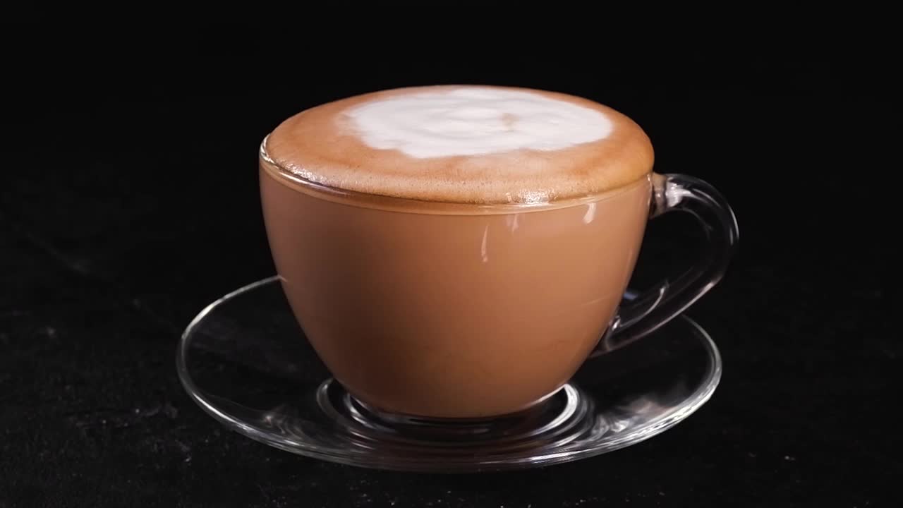牛奶滴在咖啡杯里。用牛奶煮现磨咖啡。卡布奇诺的制备过程视频下载