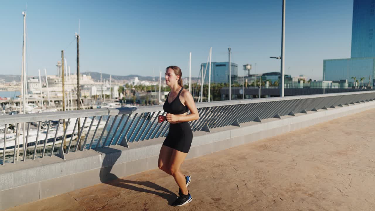 女运动员早上在港口附近慢跑视频素材
