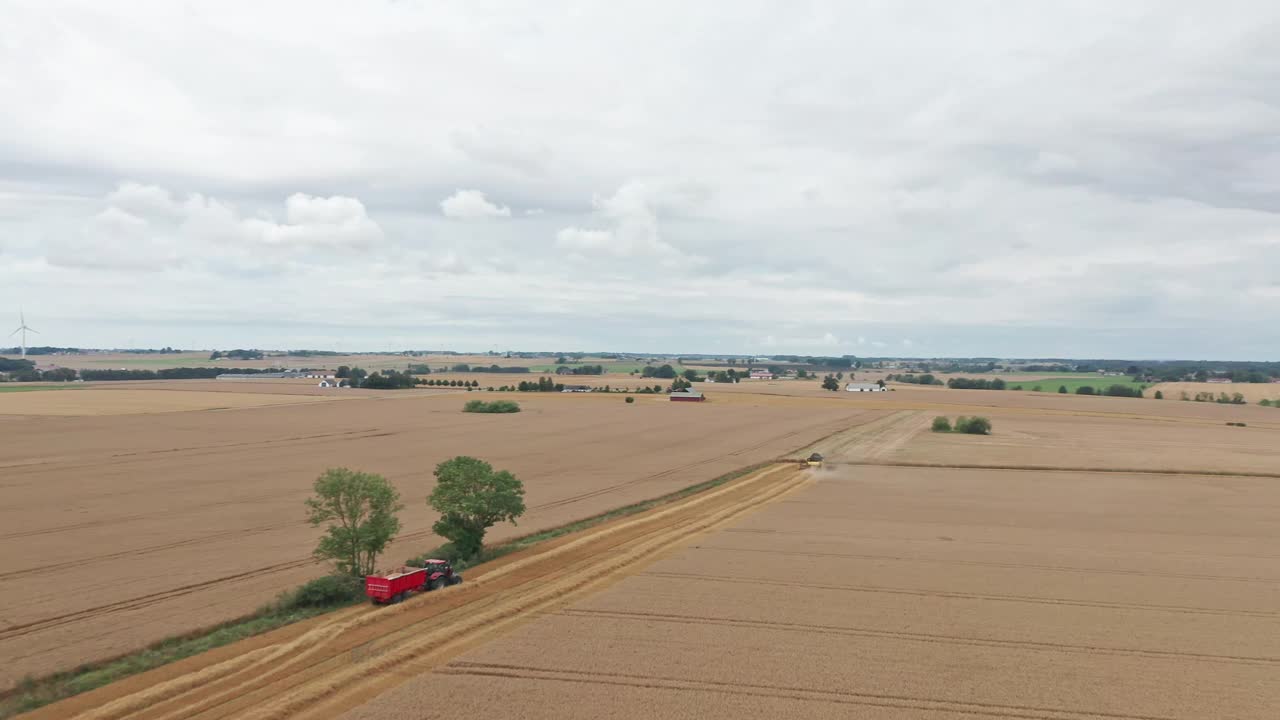 鸟瞰图广阔的农田与收割机在瑞典收获作物视频素材