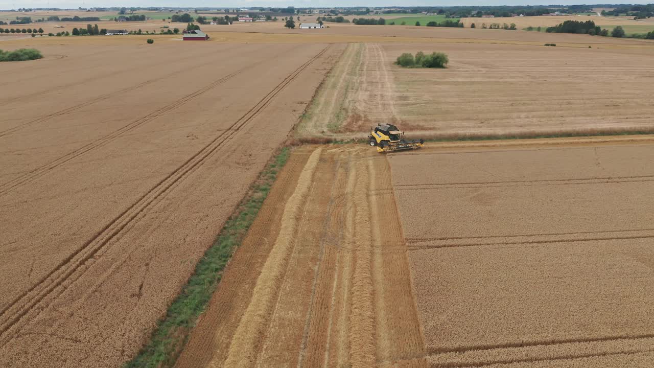 鸟瞰图广阔的农田与收割机在瑞典收获作物视频素材