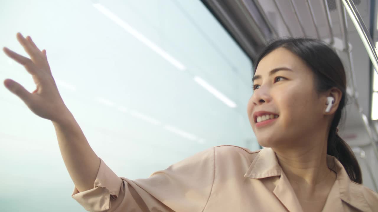 年轻的女人在火车上看着窗外，快乐的女人在火车上欣赏风景视频素材