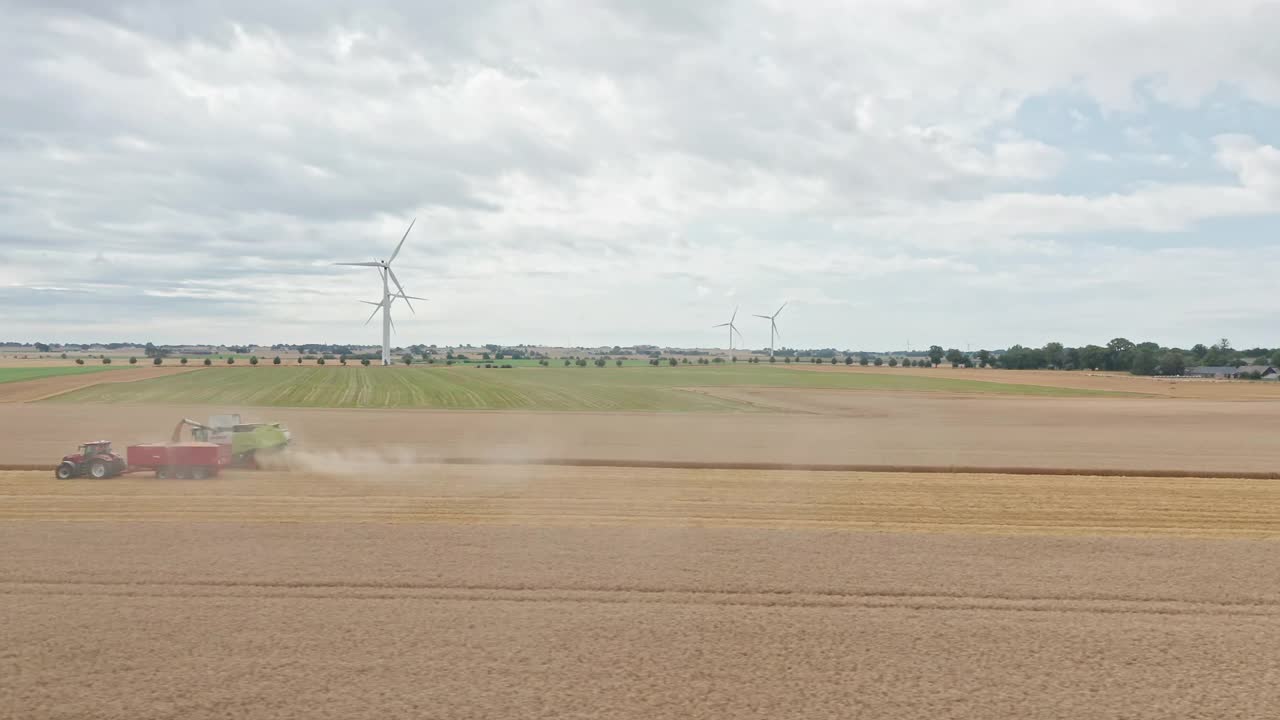 鸟瞰图的一个广阔的农业领域与收割机在瑞典收获作物视频素材