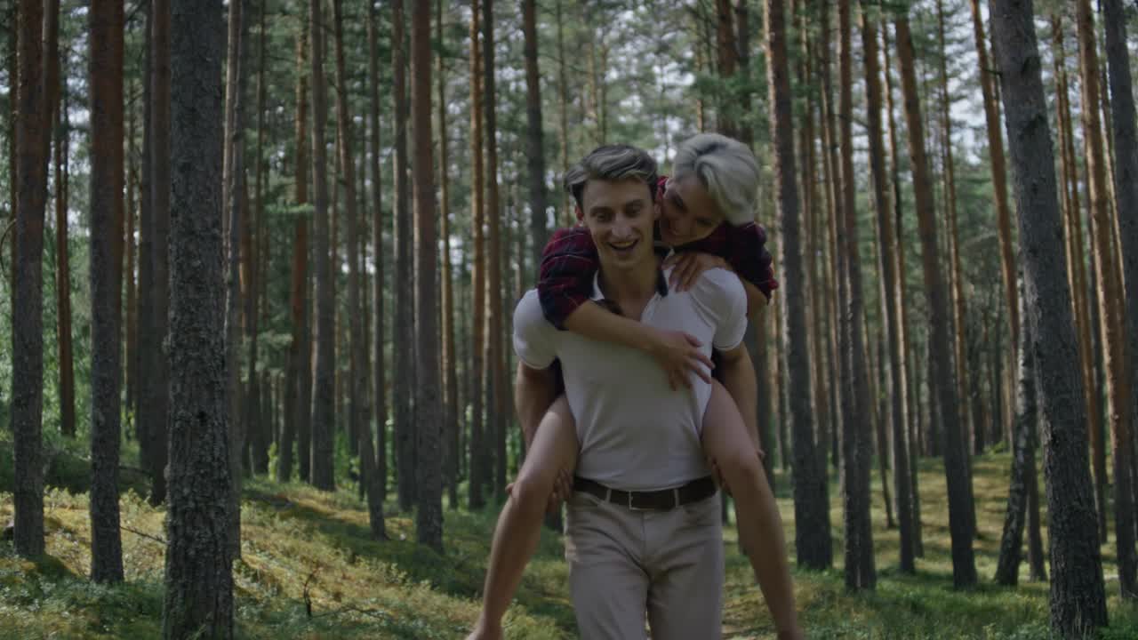 夫妻俩玩得很开心，骑着小猪在森林里奔跑视频下载