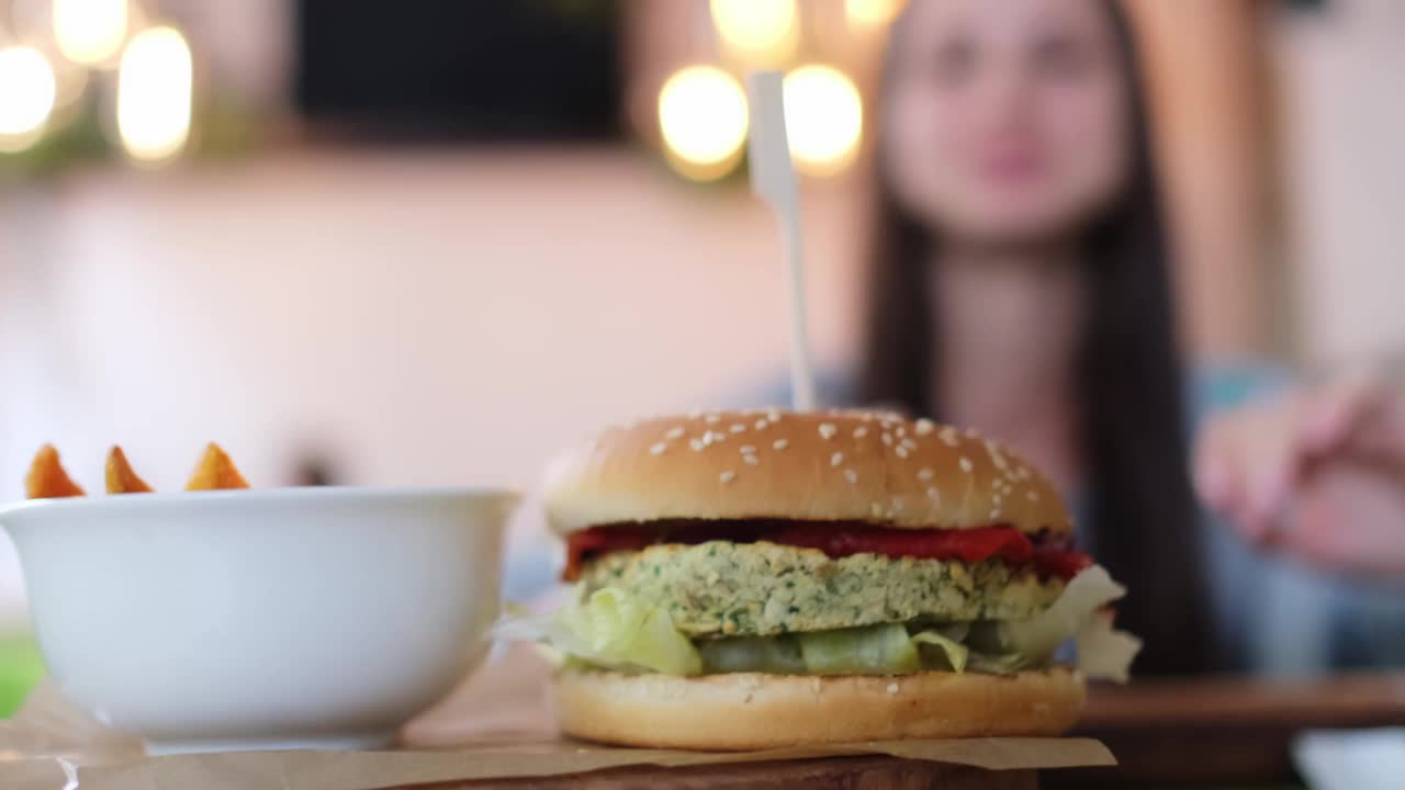一名年轻女子在素食餐厅吃素食汉堡视频素材
