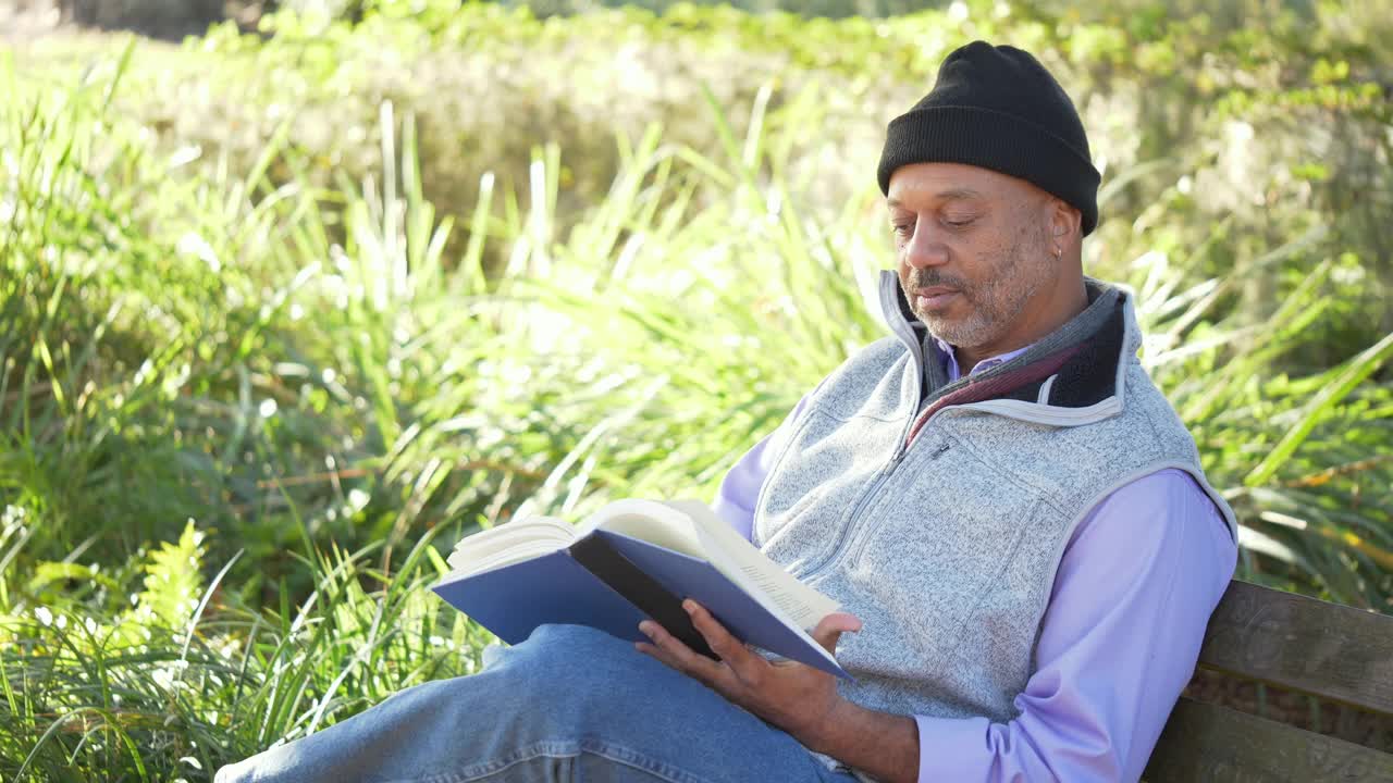 非裔美国人在公园长椅上看书视频素材