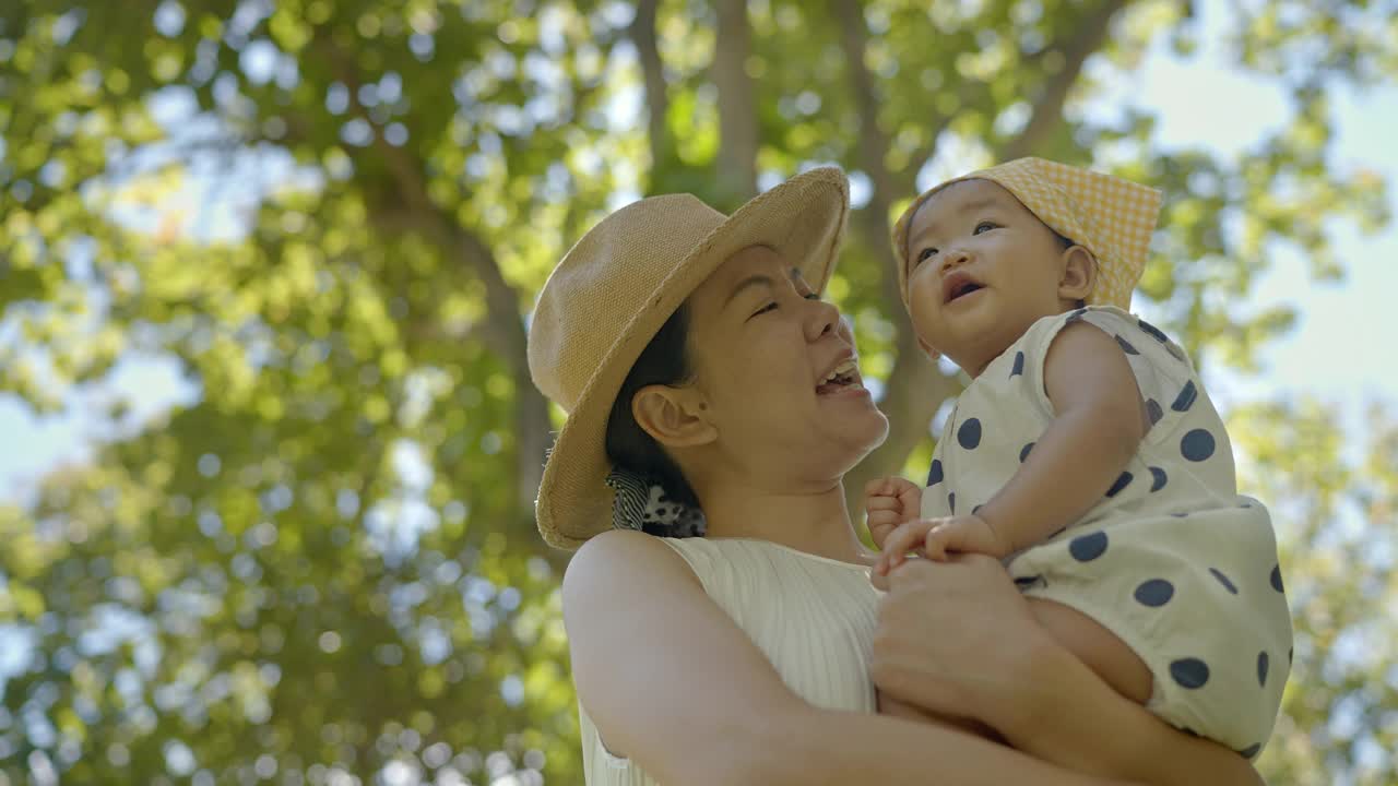 亚洲母亲穿着休闲装，拥抱着女儿，休闲野餐，户外公园和家庭正常的生活方式视频素材