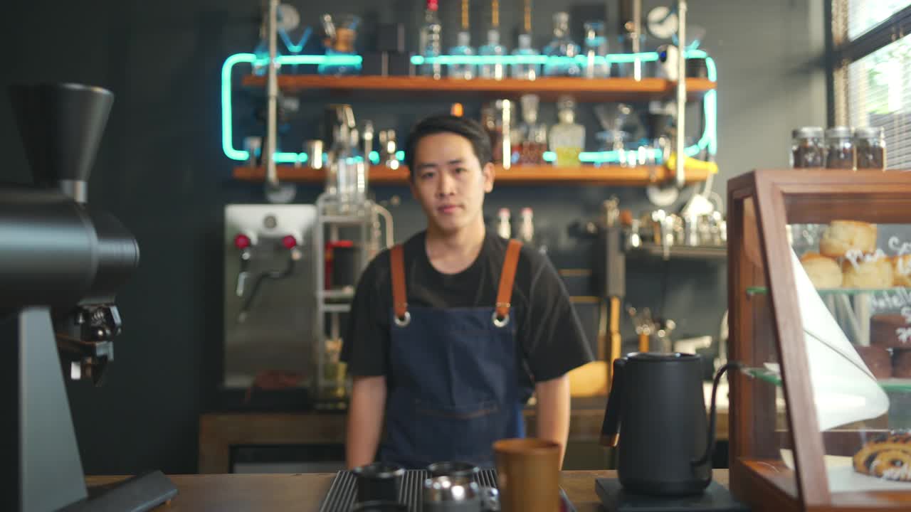 咖啡店老板的4K亚洲男人肖像，双手交叉站在吧台前视频素材