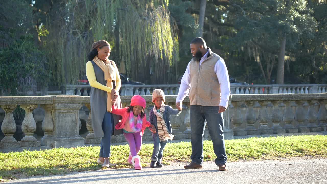 阳光明媚的秋天，黑人家庭和两个孩子在公园视频素材