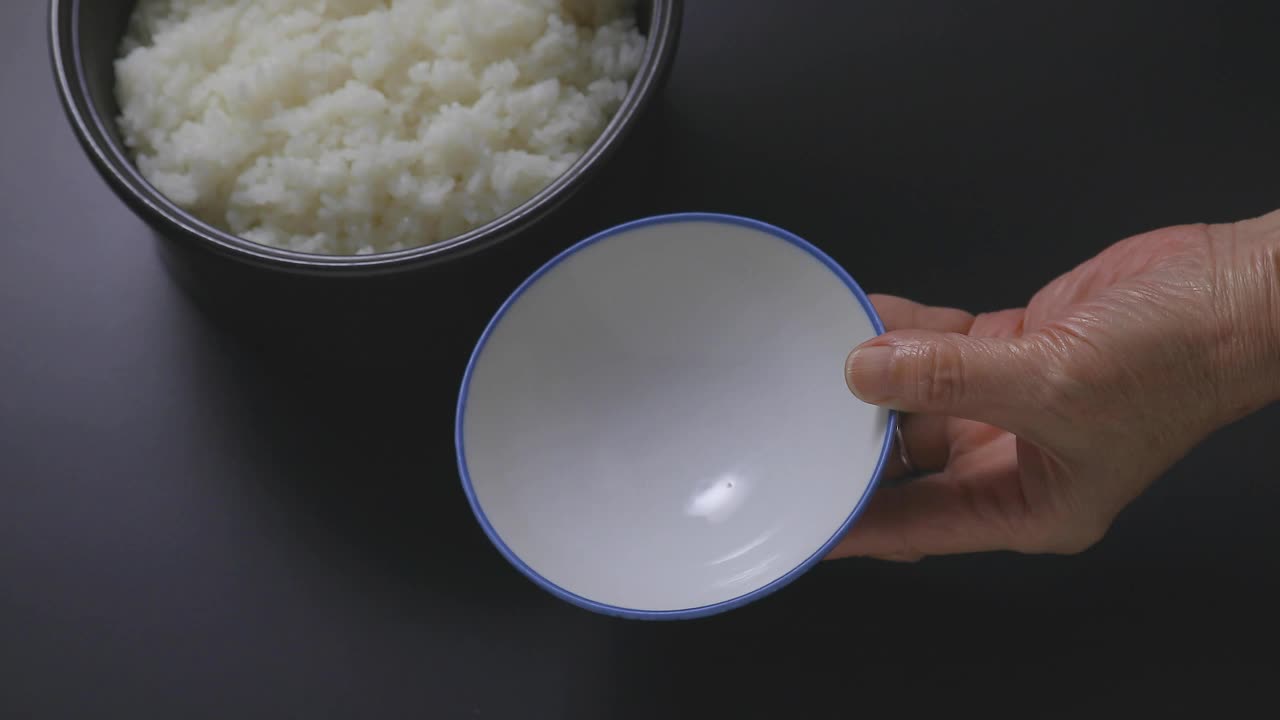 用碗盛米饭。视频素材