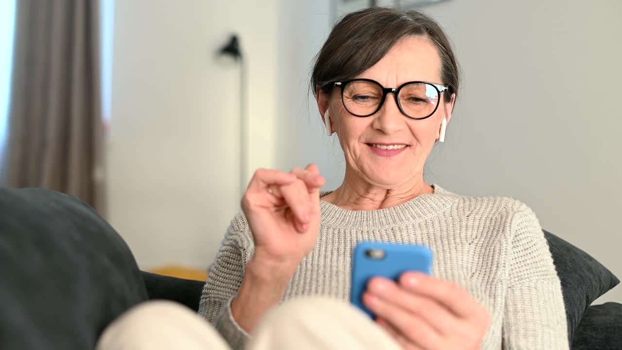 一位年长女性在家用智能手机进行视频通话视频素材