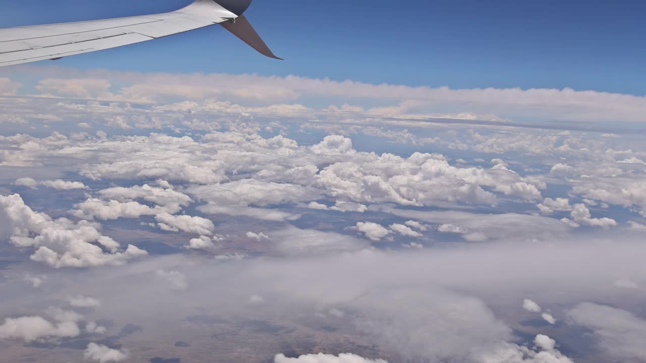 翼上的云蓝色的天空与飞行的视野从飞机窗口视频素材