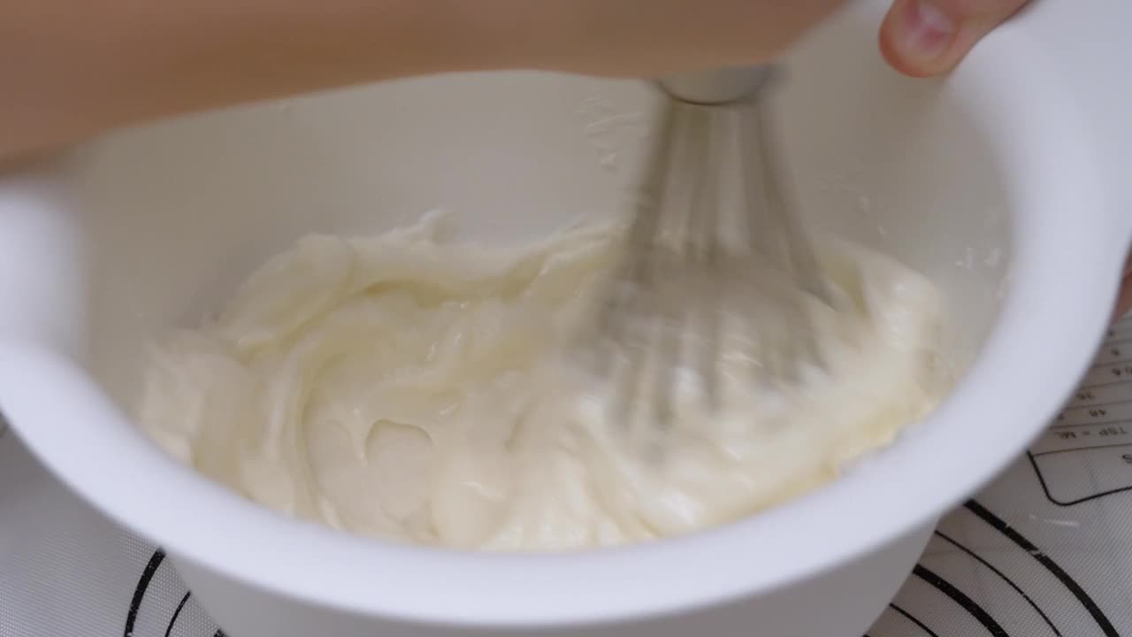 在搅拌碗中愉快地搅拌白糖粉和白鸡蛋。视频下载