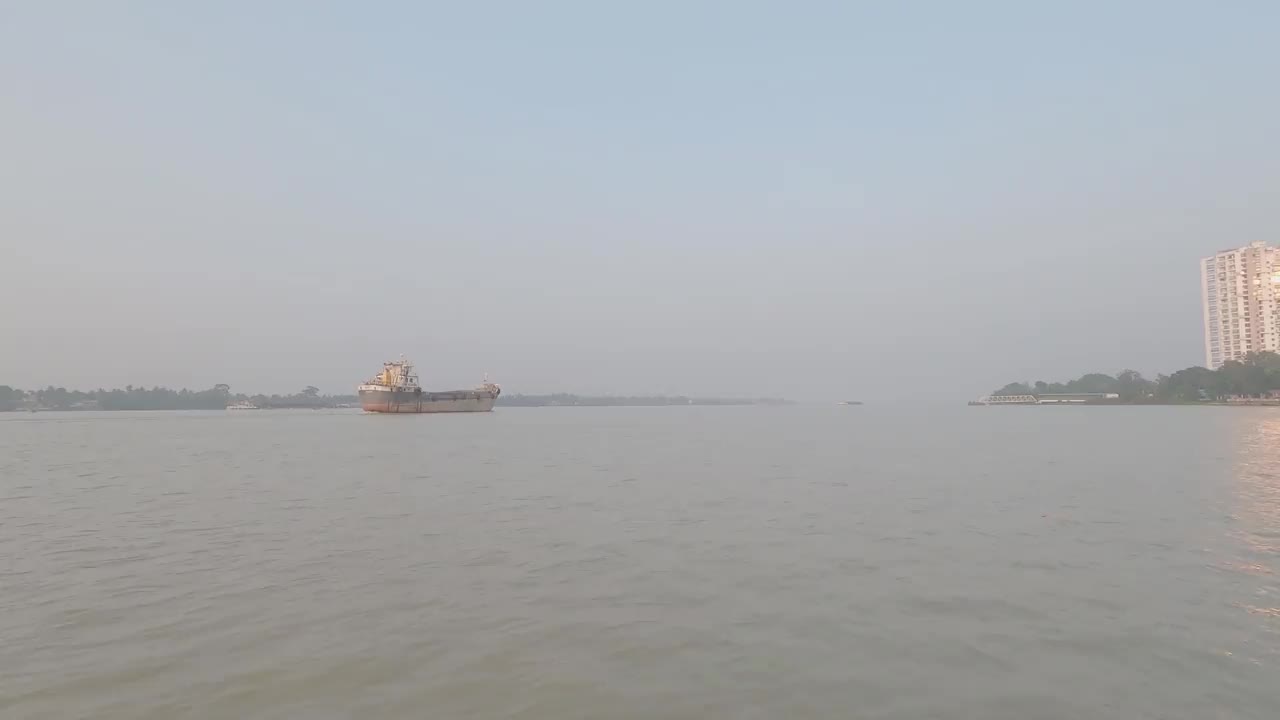 一艘集装箱货船从希迪尔普尔港启航后经过恒河。在日落的背景下，在晴朗的天空下乘船旅行的镜头。印度加尔各答亚洲视频素材