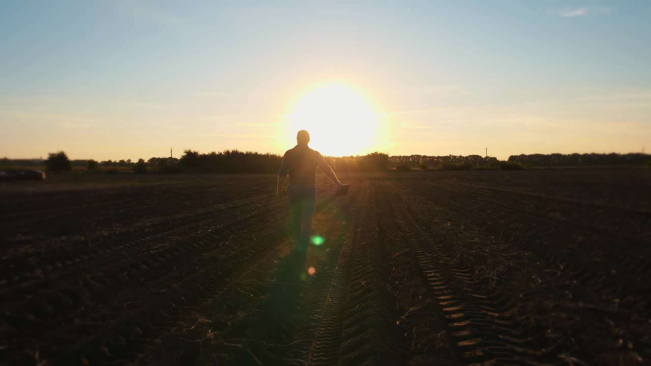 农民的剪影。日落时分，人们走在农田上。在背光。农业视频素材