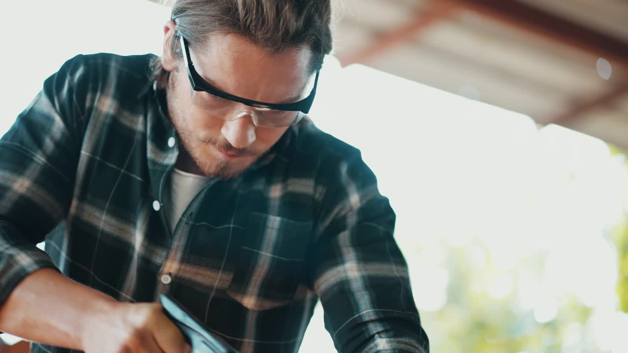 慢动作:木匠用手锯切割木材视频下载