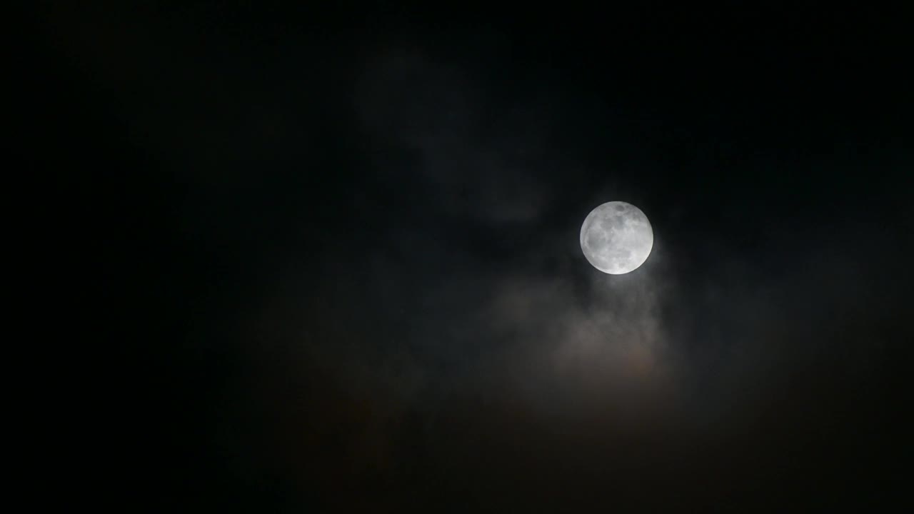 云层在满月中移动，大气看起来神秘而可怕。4 k的视频。视频素材