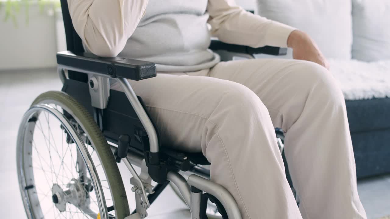 残疾人按摩受伤的腿，坐在轮椅上，康复中心视频素材