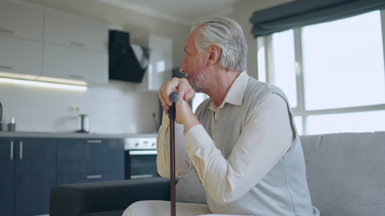 退休老人拄着拐杖，在空荡荡的公寓里感到悲伤，孤独视频素材