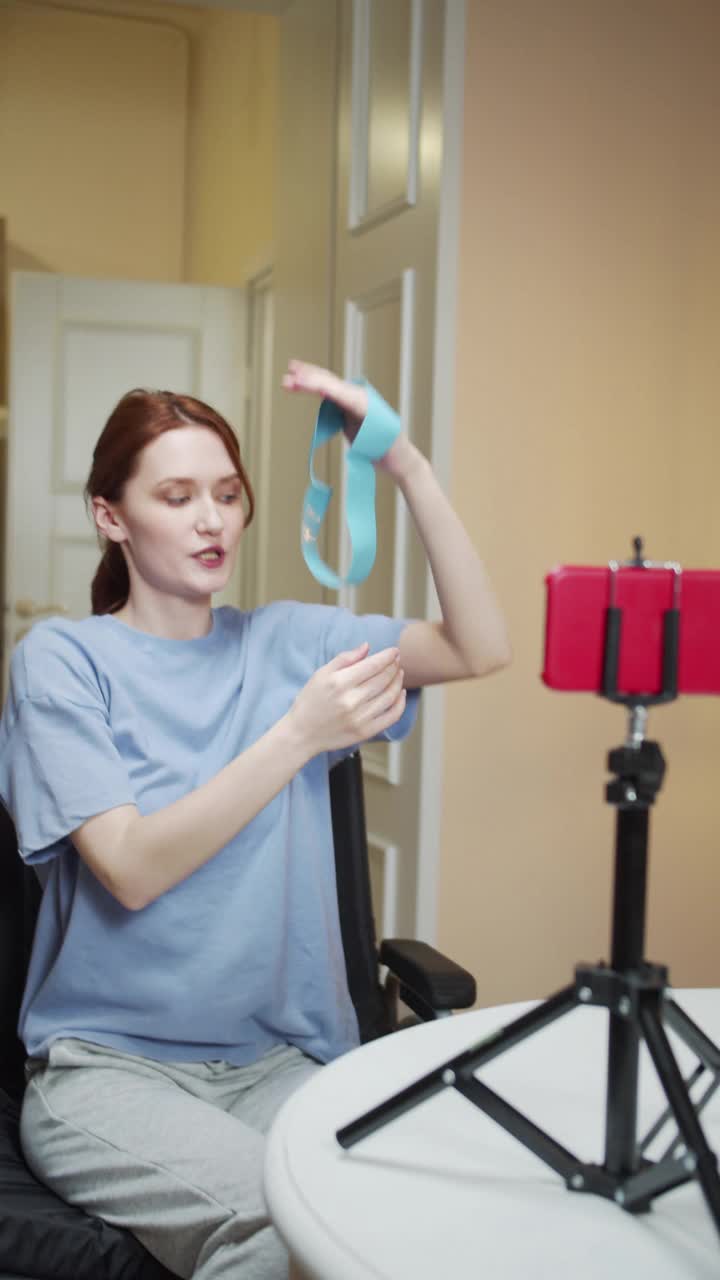 一位残疾的运动妇女正在用运动松紧带展示一项运动视频素材