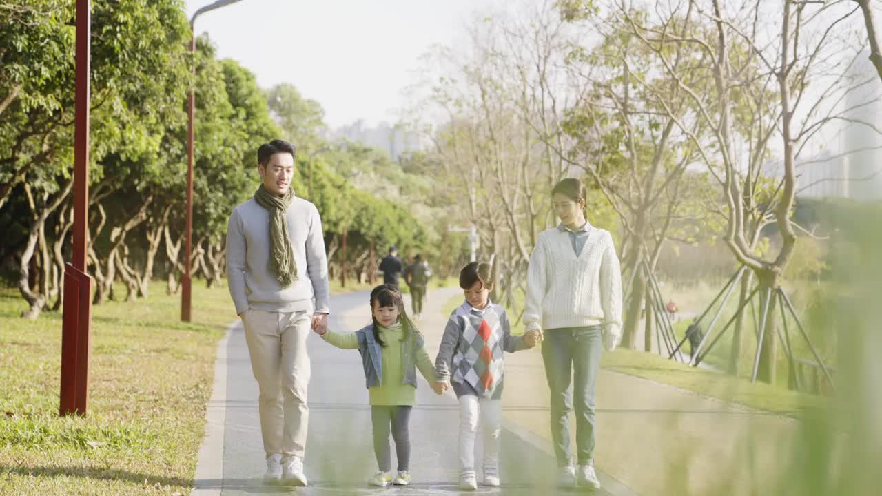 亚洲家庭在公园里散步放松视频素材
