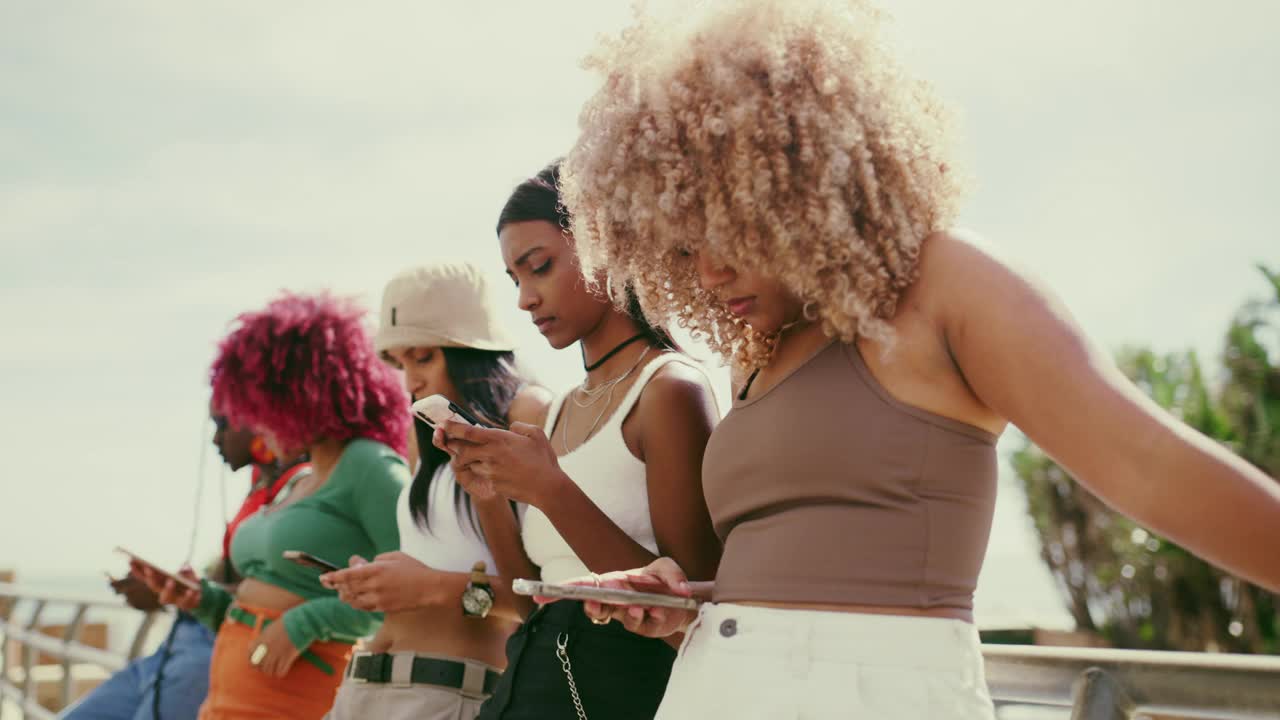 一群女性朋友站在外面用手机的4k视频片段视频下载