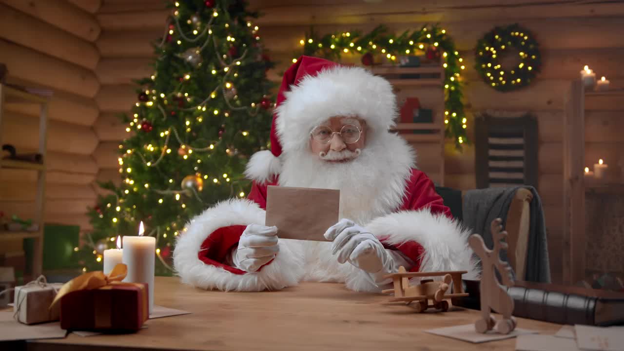 圣诞老人拿着一个普通的信封，在镜头前竖起大拇指视频素材