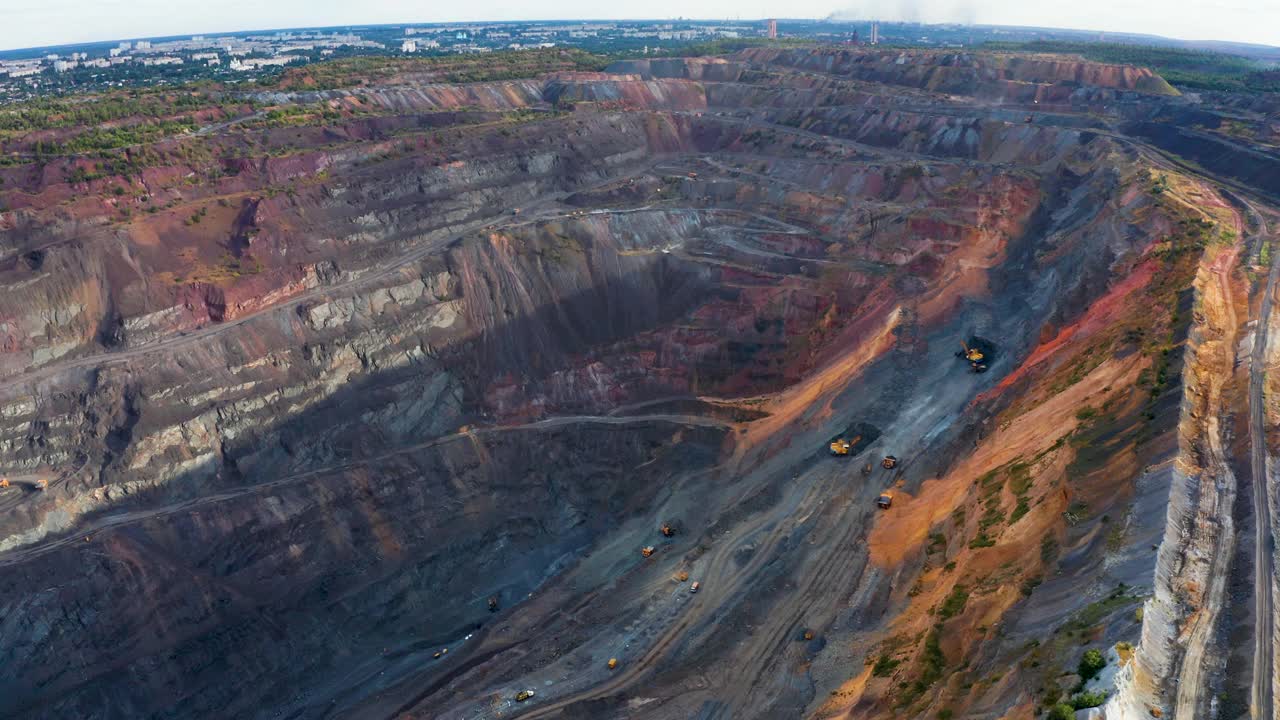 露天铁矿及重型采矿设备鸟瞰图。视频素材