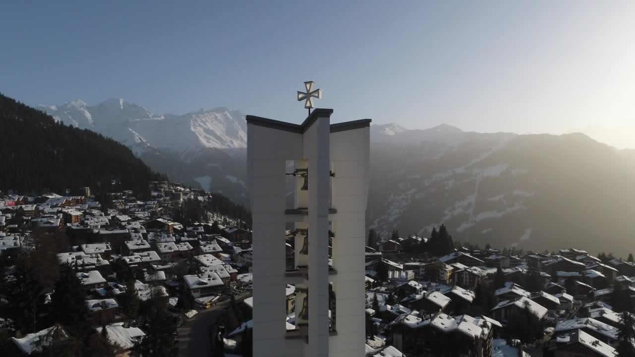 空中拍摄的教堂在黎明时分，在一个美丽的瑞士村庄覆盖在雪视频素材