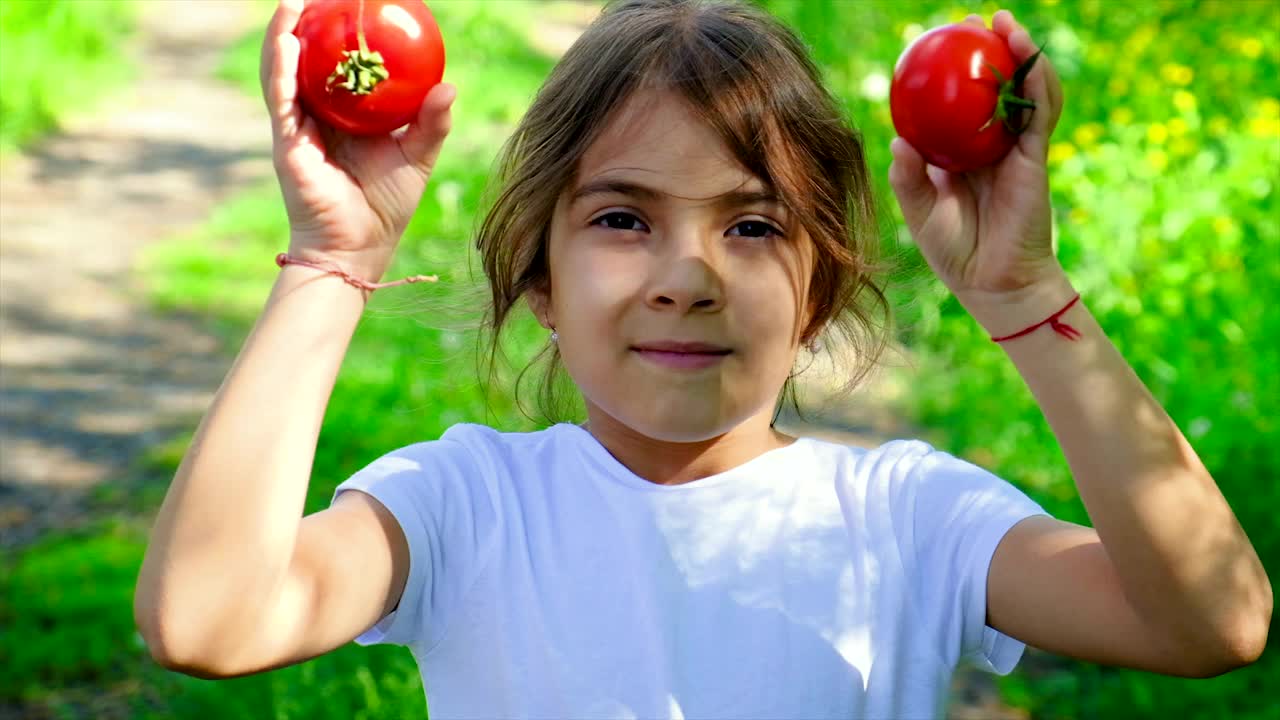孩子手里拿着蔬菜和西红柿。有选择性的重点。视频素材