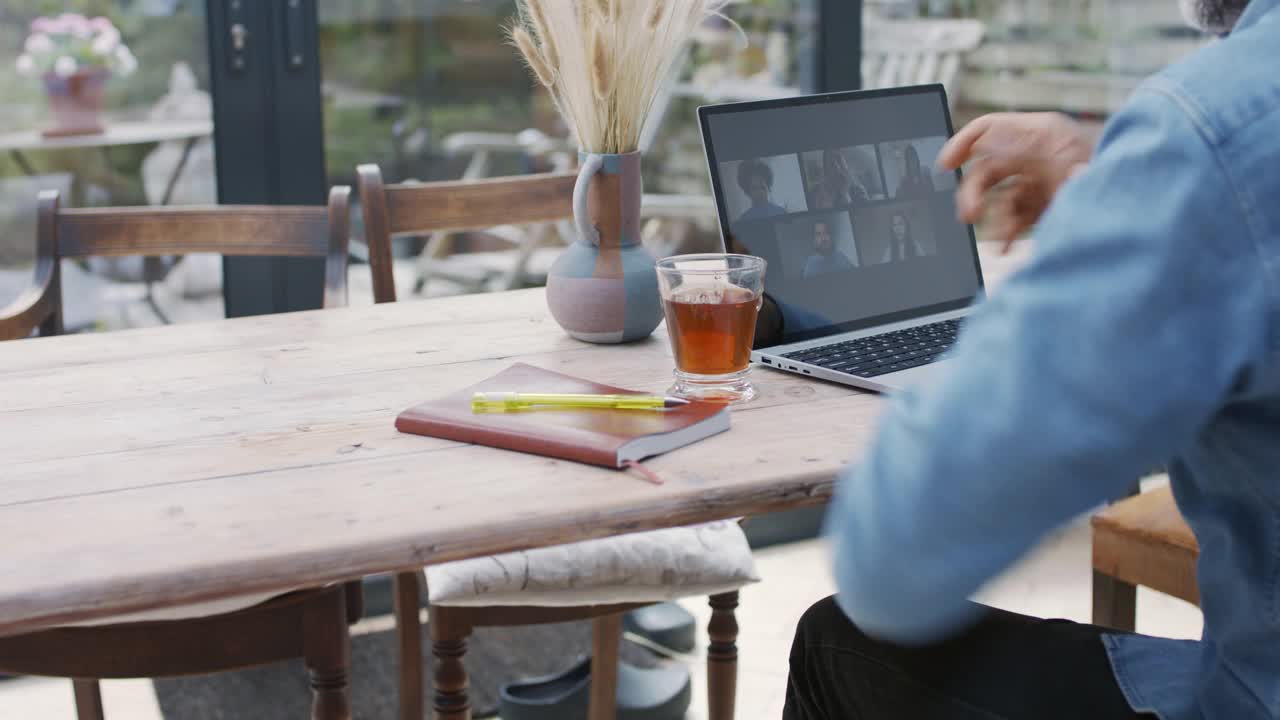 一个成熟的男人在和同事视频通话时喝着茶视频下载